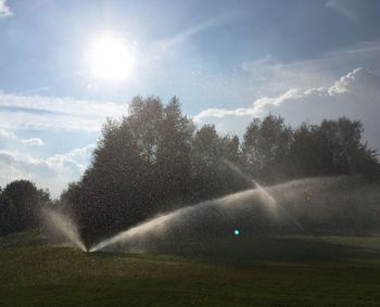 Water splashing in car against sky