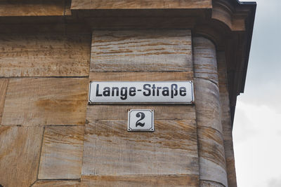 Low angle view of information sign on wall