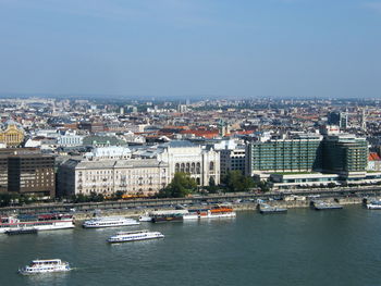 River amidst buildings in city against clear sky