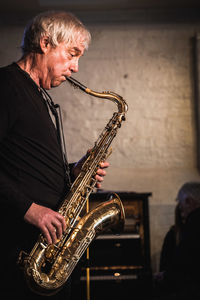 Side view of man playing saxophone