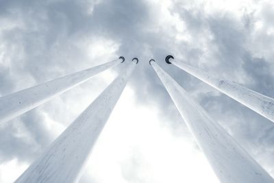 Low angle view of bird flying against cloudy sky