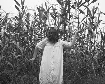 Rear view of woman standing on field