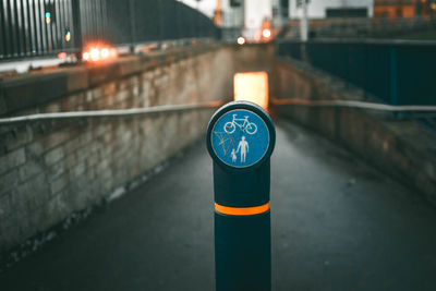 Close-up of arrow sign on road at night