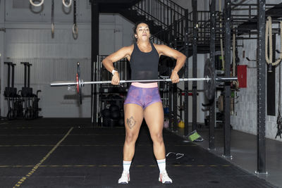 Latin woman lifting weights in a gym