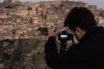 Rear view of man photographing cityscape