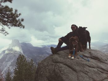 Man with dogs sitting on rock at washburn point