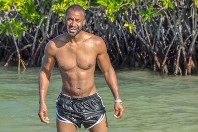 Portrait of shirtless man standing in lake