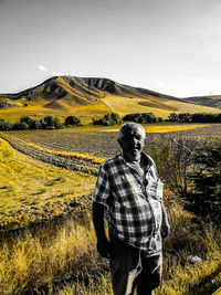 Man standing on field against sky
