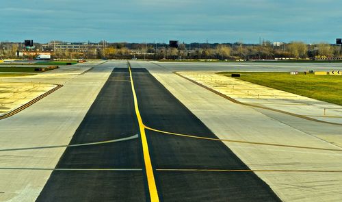 View of empty airport runway against sky