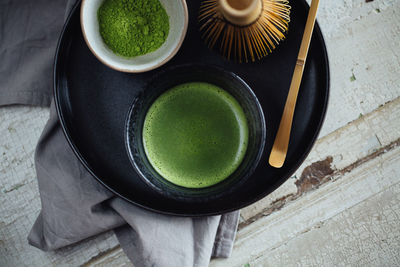 High angle view of cup of matcha tea on table