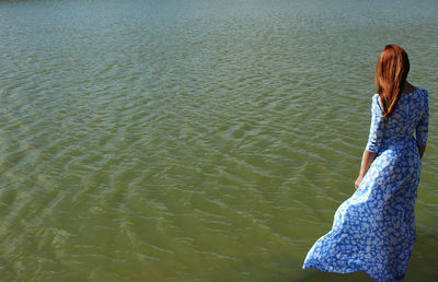 Rear view of woman standing in sea