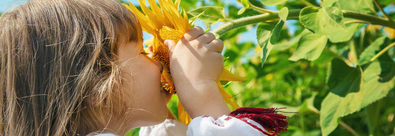 Cute girl smelling sunflower