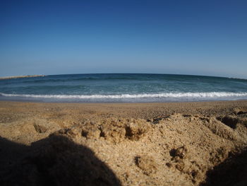 Scenic view of beach against clear blue sky