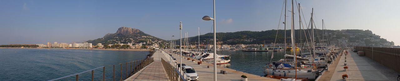 Panoramic view of boats moored in sea against sky