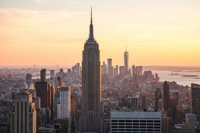 Skyscrapers in city at sunset