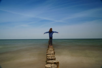 Full length of man standing at sea shore against sky