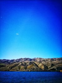 Scenic view of lake against clear blue sky