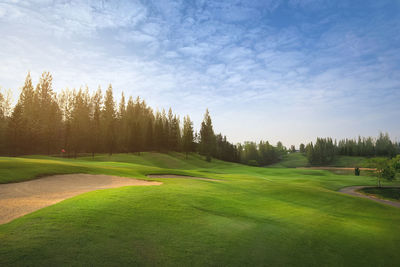 Scenic view of golf course against sky