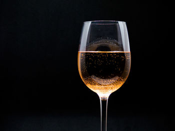 Close-up of wineglass against black background