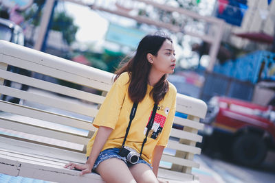 Young woman looking down while sitting outdoors