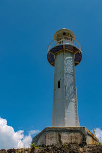 Low angle view of lighthouse by building against sky