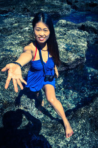 Portrait of smiling young woman on rock