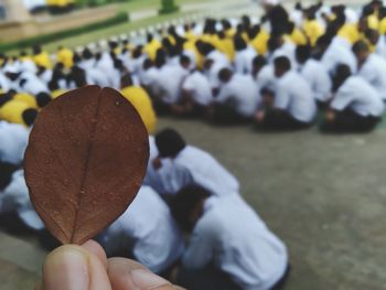 Close-up of hand holding autumn leaves