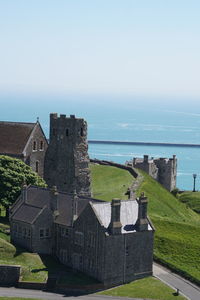 Built structure by sea against clear sky