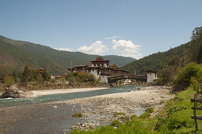 Scenic view of building by mountains against sky