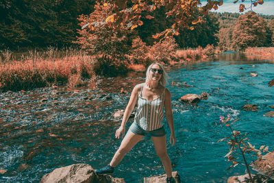 Portrait of young woman standing against plants