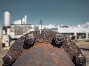 Close-up of rusty metal chain against clear sky