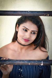 Portrait of young woman looking through window