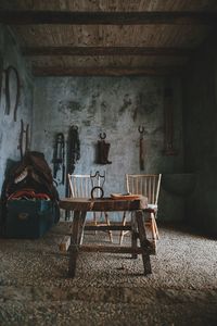 Empty chairs and table in abandoned building