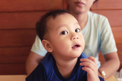 Close-up of cute boy with mother at home