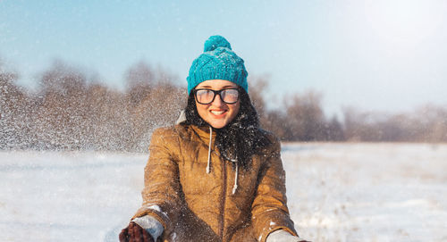 Portrait of smiling woman standing in snow