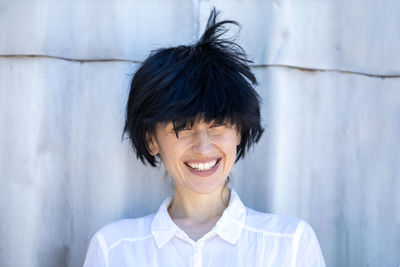 Smiling woman standing against wall