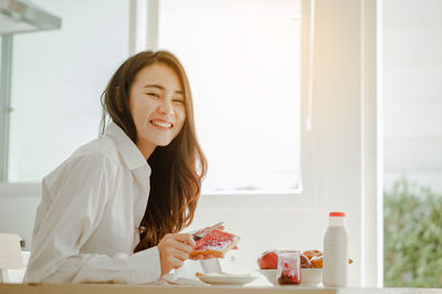 Portrait of smiling woman with chocolate on table