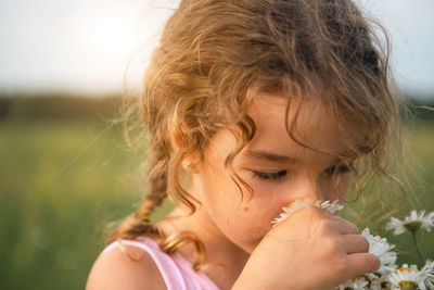 Cute girl smelling flowers