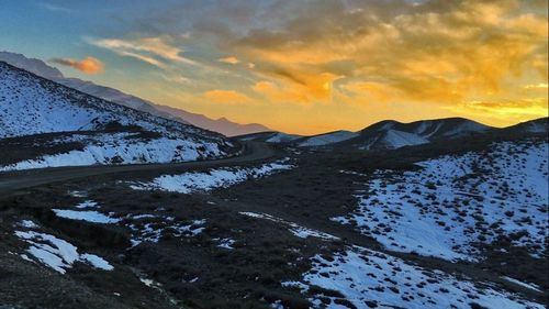 Scenic view of snowcapped mountains against sky during sunset