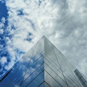 Low angle view of modern building against cloudy sky