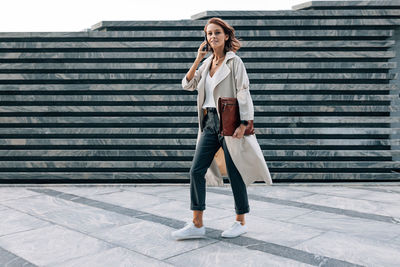 Full length of young woman standing on steps