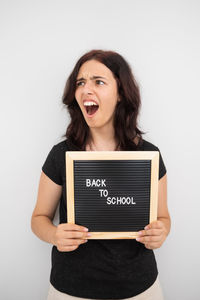 Young woman using digital tablet against white background