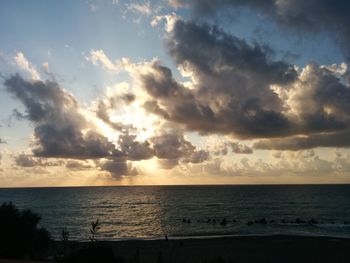 Scenic view of sea against cloudy sky at sunset