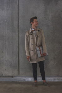 Young man standing against wall