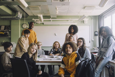 Portrait of diverse students with teachers in classroom at school