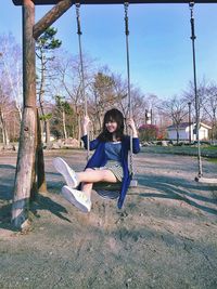 People sitting on swing in park