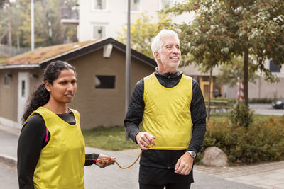 Visually impaired woman preparing for jogging with guide runner