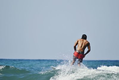 Woman jumping in sea