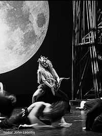 Woman sitting on sculpture against sky at night