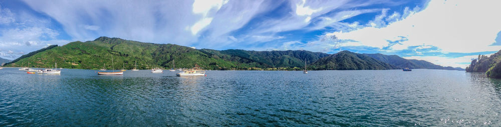 Scenic view of sea by mountains against sky